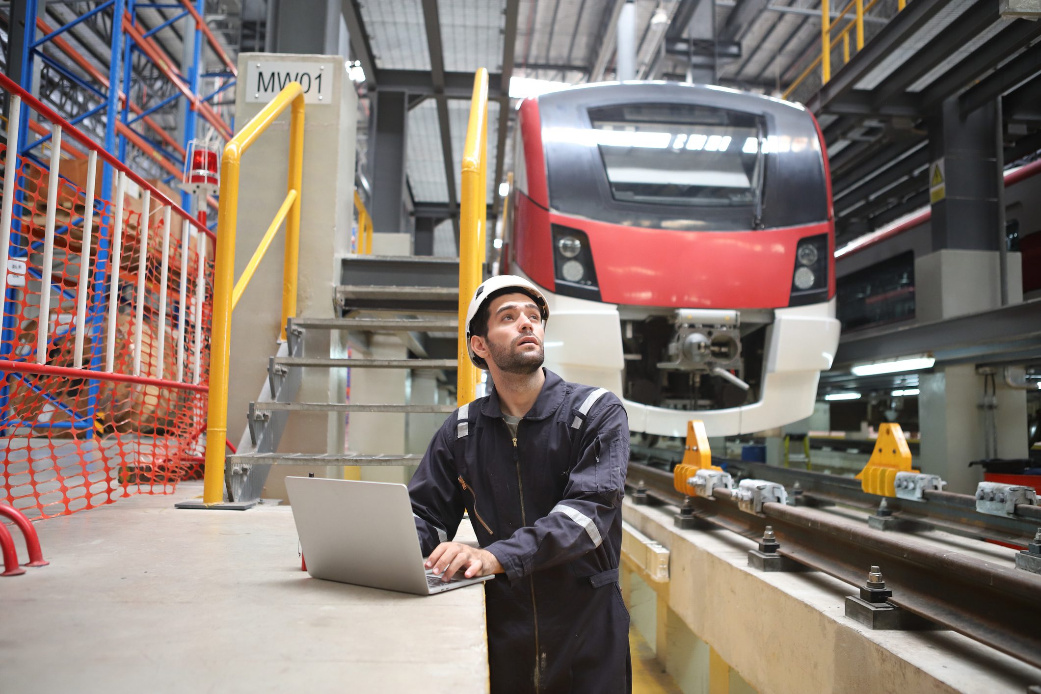 Engineer working near train in maintenance facility.