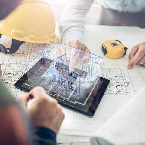 Architects reviewing digital house model on tablet.